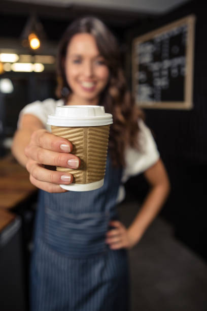 istock Smiling barista holding disposable cup 675089588