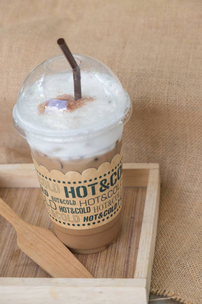 istock Iced coffee mocha with ice in plastic cup on wood tray 675095260