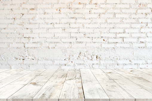 Empty clear white wood table for product placement or montage, perspective style. vintage white brick wall background.