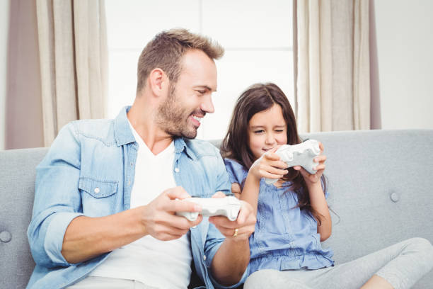 istock Father playing video game with daughter at home 675098866