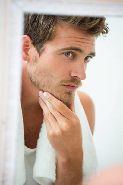 istock Man checking his stubble in bathroom 675171418