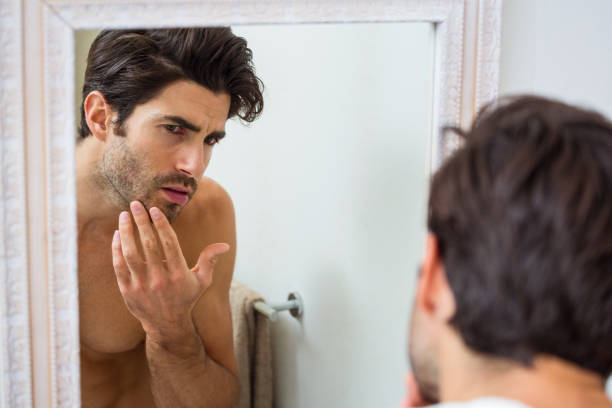 istock Man checking his stubble in bathroom 675172194