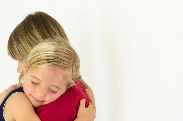 Mother and her cute blond daughter hugging
