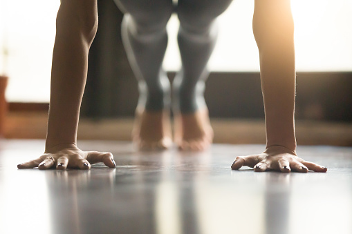 Mujer yogui joven de pie en la pose de Plank, Backgroun interior del hogar photo