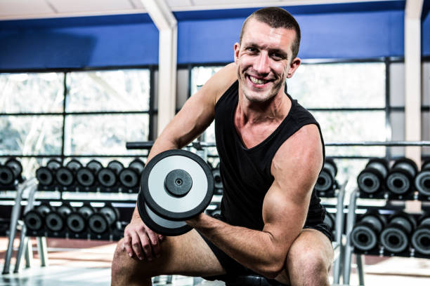 istock Muscular man exercising with dumbbells 675173954