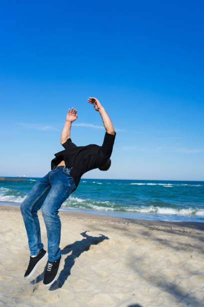 hombre joven parkour haciendo flip o salto - back somersault fotografías e imágenes de stock