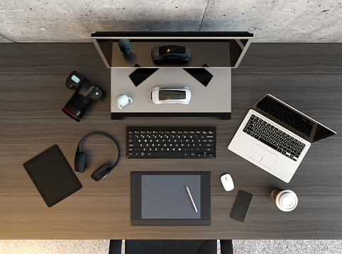 Top view of graphic designer desktop with laptop, digital graphic tablet, DSLR camera, wireless headphone and keyboard. 3D rendering image.