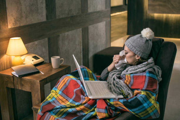 istock Woman which has a flu working from home on a laptop 675192550