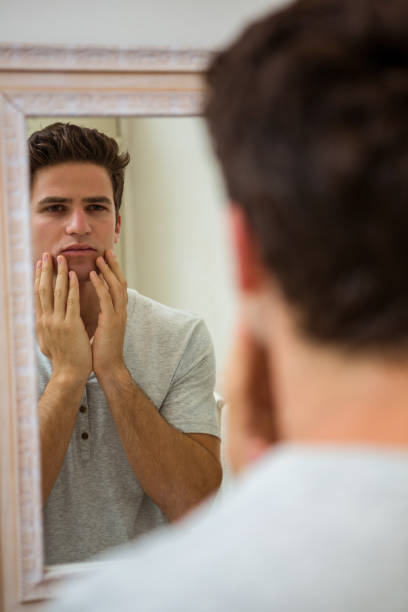 istock Man checking his skin in bathroom 675193164