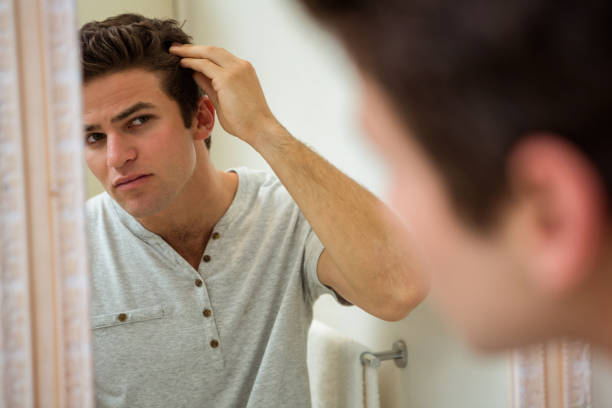 istock Man checking his hair in mirror 675193182