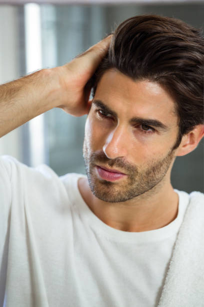 hombre verificar su cabello - mano en el cabello fotografías e imágenes de stock