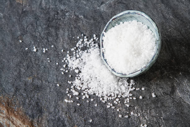 istock Sea salt on a dark stone background 675200374