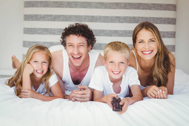 istock Smiling family resting on bed 675200512
