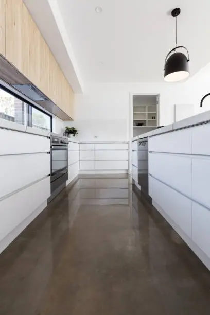 Long galley style kitchen with polished concrete floor