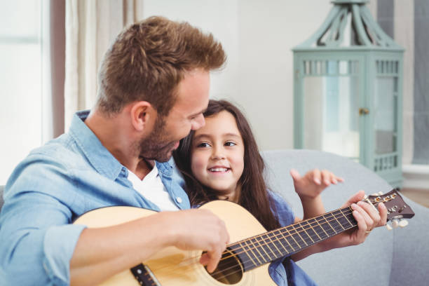 istock Young man playing guitar with daughter 675202990