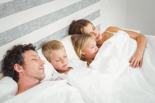 istock High angle view of family relaxing on bed 675203174