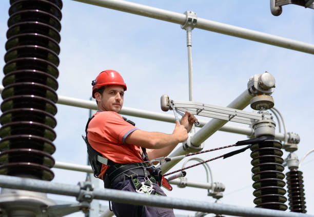 istock Electrician with protective workwear, hardhat and safety harness working 675203612