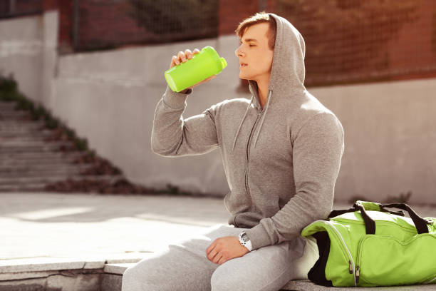 istock Young active man drinking water, outdoors. Handsome muscular male holding shaker 675206262