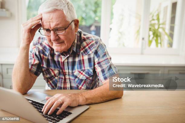 Hombre Senior Preocupado Usando Laptop Foto de stock y más banco de imágenes de Ordenador - Ordenador, Hombres mayores, Preocupado