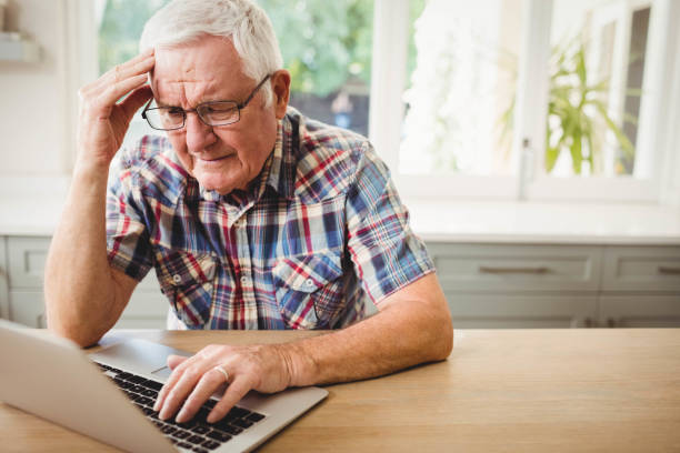 Worried senior man using laptop