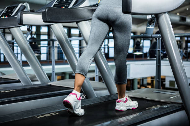 istock Mid section of woman using treadmill 675209074