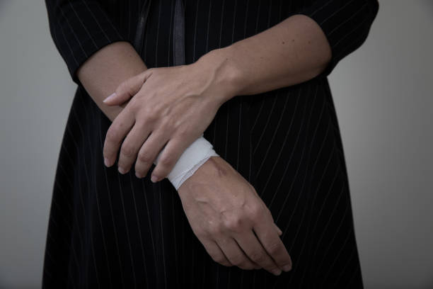 Middle age woman showing her bandaged wrist. Middle age woman showing the scars of self harm. self harm photos stock pictures, royalty-free photos & images