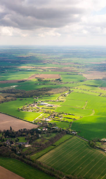 istock Aerial view from plane on green meadows and fields in cloudy day with sun rays spots 675219478