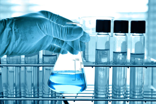 istock Flask in scientist hand with laboratory glassware background 675219706