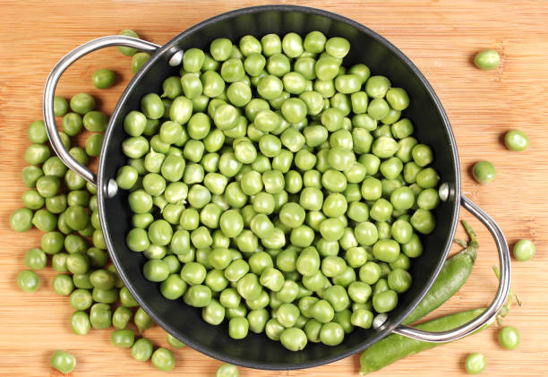 istock Green peas on the wooden board    on   white background 675219868