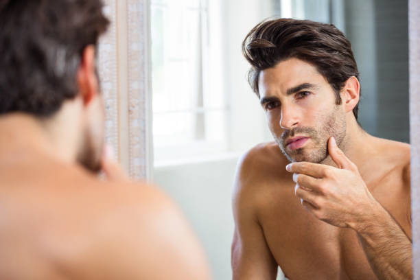 istock Man checking his stubble in bathroom 675220098