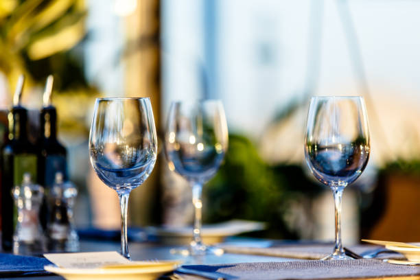 istock Wine glass stands on the table in the restaurant. Evening, the setting sun. 675226932