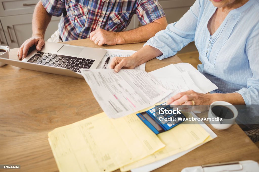 Senior couple checking their bills Senior couple checking their bills at home Financial Bill Stock Photo