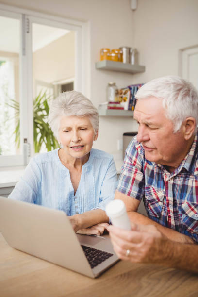 istock Senior couple holding a pill bottle while operating laptop 675233590