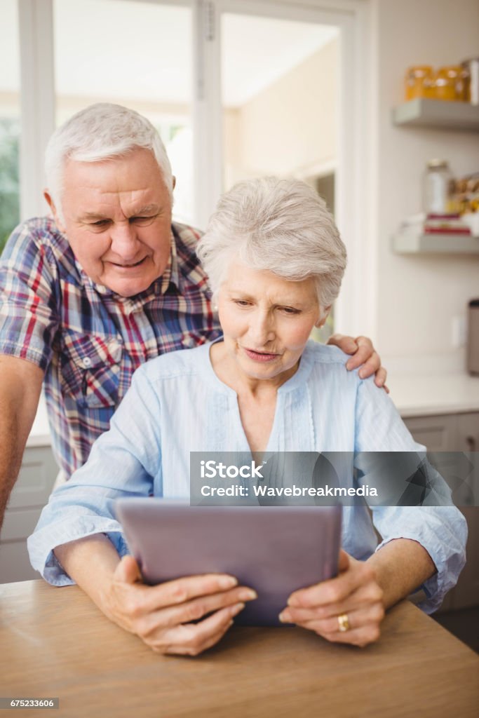 Senior couple looking at a digital tablet Senior couple looking at a digital tablet at home 70-79 Years Stock Photo