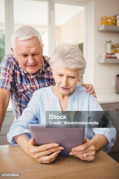 Senior Couple Looking At A Digital Tablet Stock Photo - Download Image Now - 70-79 Years, Active Lifestyle, Active Seniors