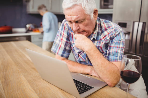 istock Senior man using laptop and woman working in kitchen 675233876