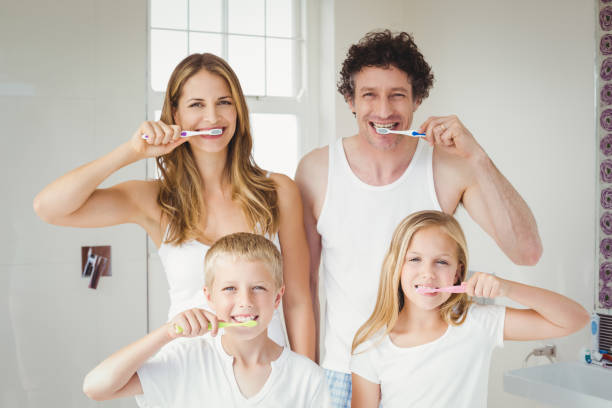 ritratto di famiglia sorridente che lava i denti - dental hygiene human teeth toothbrush brushing teeth foto e immagini stock