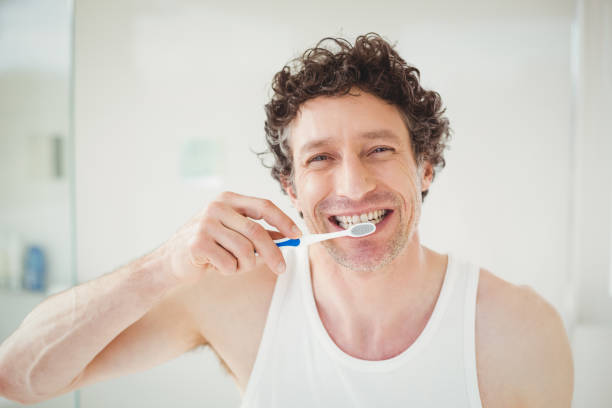 istock Portrait of young man brushing teeth 675239748