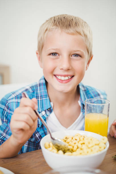 istock Happy boy having breakfast at table in house 675240876