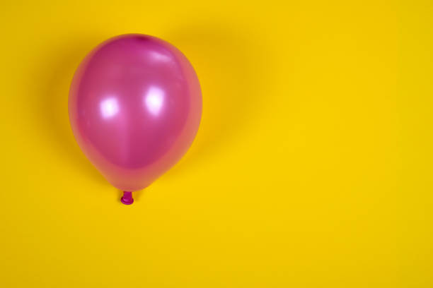 Shiny metallic heart and star balloons float on a vivid yellow backdrop, conveying festive celebration, playfulness, and bold color. Ideal for party, event, or milestone promotions and creative campaigns.