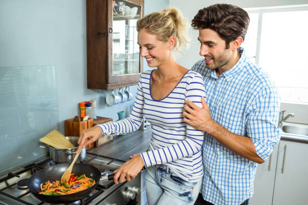 istock Young couple preparing food together in kitchen 675251298
