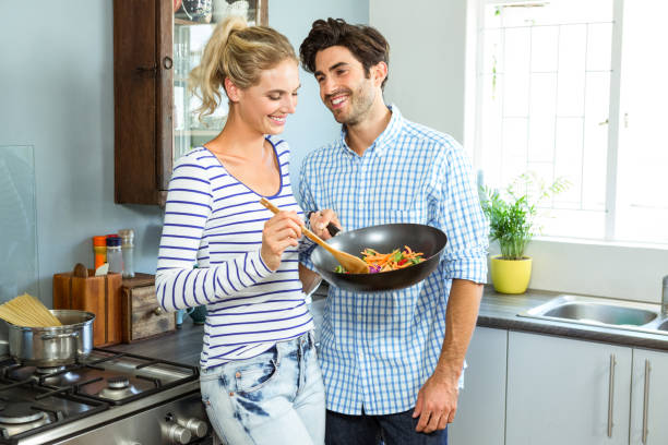 istock Young couple preparing food together in kitchen 675251450