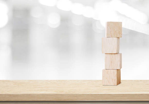 istock Four wooden cubes on table over blur abtract bokeh light background, black and white 675258870