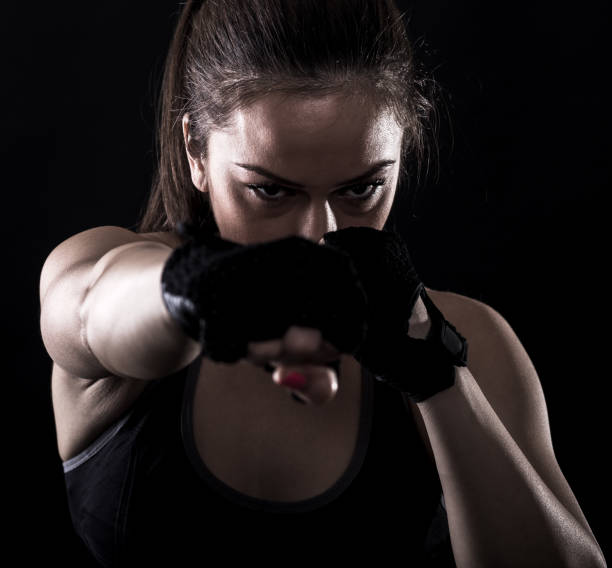 istock Studio shot of female boxer punching. 675259536