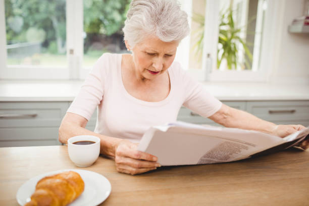 istock Senior woman reading a newspaper 675261928