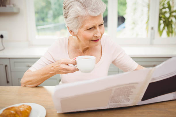 istock Senior woman reading a newspaper 675261976
