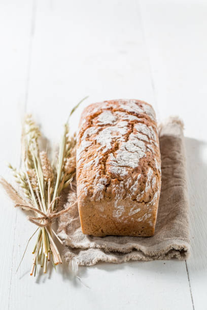 istock Tasty and fresh bread with several grains on white table 675262170