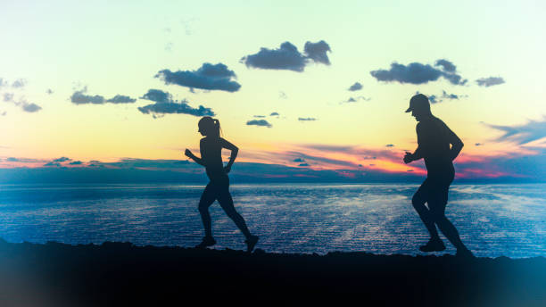 istock Couple running at the sea side at sunset 675265292