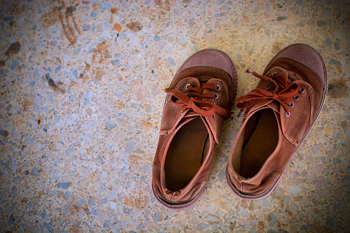 Brown shoes on limestone floor.