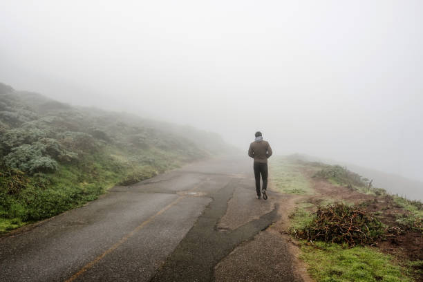 istock Lone man walking through the white fog 675272158